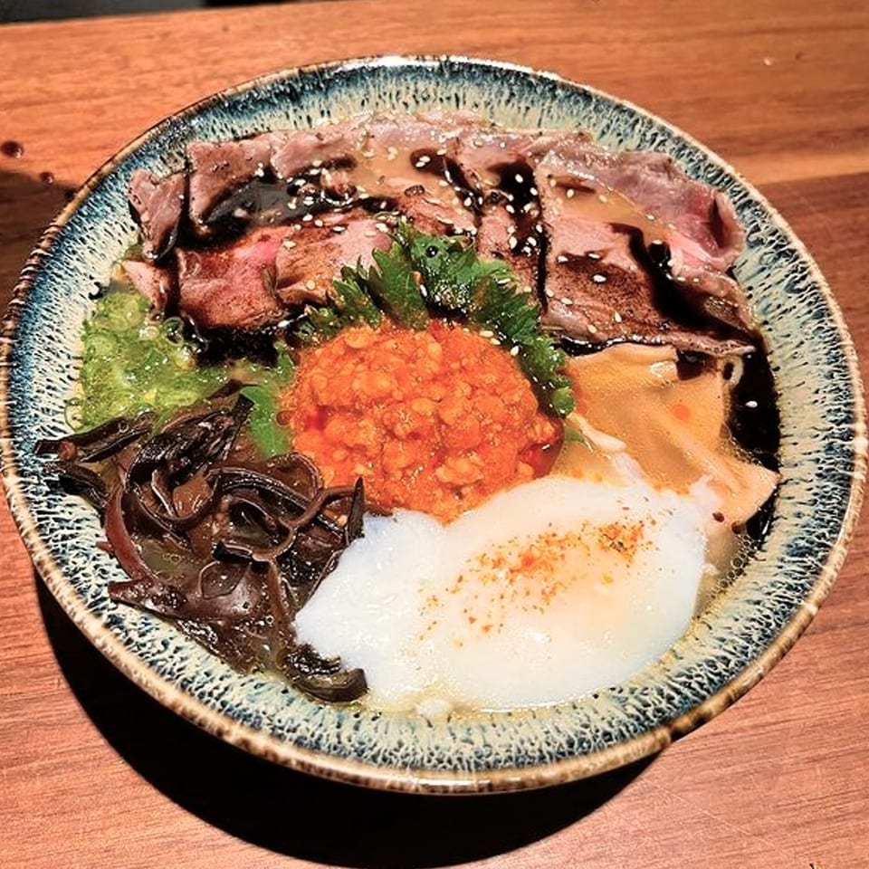 Shiso Noodle and Sushi Bar's beef bowl with egg, red paste, and dark mushrooms.